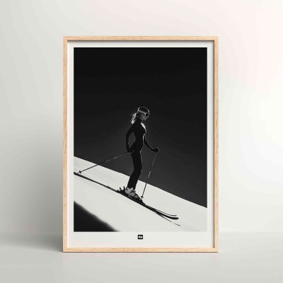 Schwarz-Weiß-Foto einer Skifahrerin bei der Abfahrt. Design-Wandposter von Skifahren für moderne Innendekoration. Schwarz-Weiß-Foto einer Skifahrerin bei der Abfahrt. Design-Wandposter von Skifahren für moderne Innendekoration.