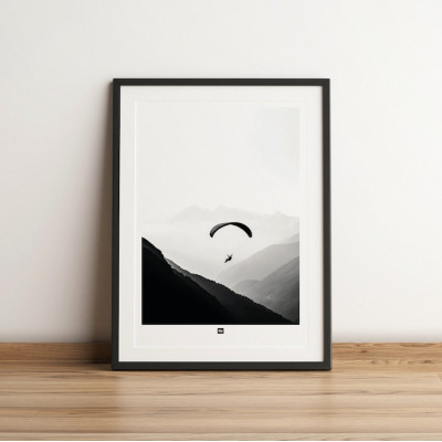 Black and white photo of a paraglider in the air above the mountains. Design wall poster for modern decor. Black and white photo of a paraglider in the air above the mountains. Design wall poster for modern decor.
