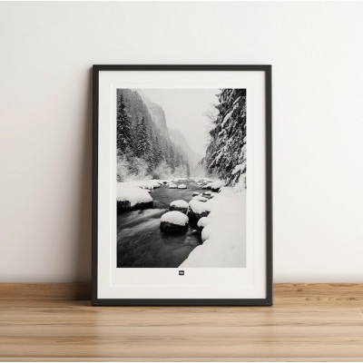 Black and white photo of a river surrounded by fir trees in the mountains. Modern, designer winter wall hanging. Black and white photo of a river surrounded by fir trees in the mountains. Modern, designer winter wall hanging.