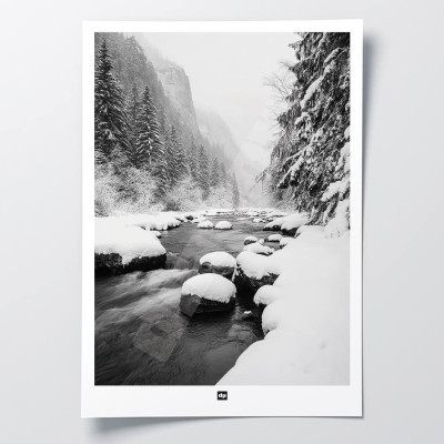 Black and white photo of a river surrounded by fir trees in the mountains. Modern, designer winter wall hanging.