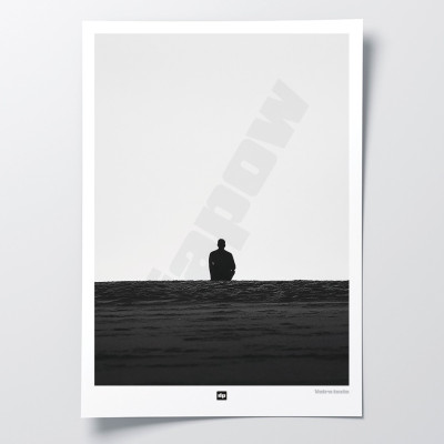 Black and white photo of a man gazing at the endless horizon. A designer wall poster with a seaside theme.