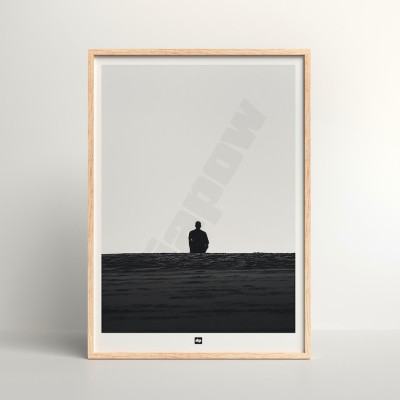 Black and white photo of a man gazing at the endless horizon. A designer wall poster with a seaside theme.