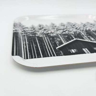 Küchenbrett aus Holz von Diapow mit der Abbildung einer Hütte vor einem Wald aus schneebedeckten Tannen in Schwarz-Weiß.