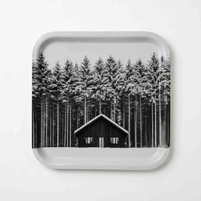 Plateau de cuisine en bois Diapow représentant un chalet devant une forêt de sapins enneigés en noir et blanc.