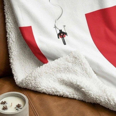 Plaid XL blanc, doux et épais, avec drapeau de Savoie posé sur un canapé.
