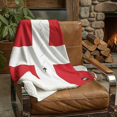 Plaid XL blanc, doux et épais, avec drapeau de Savoie posé sur une chaise devant une cheminée.